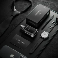 Luxury perfume bottle and packaging arranged with sophisticated black accessories.
