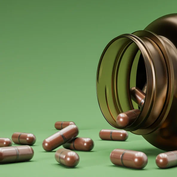 Open amber supplement bottle spills brown capsules across a green surface, with a herbal label visible; the scene feels natural and calm.