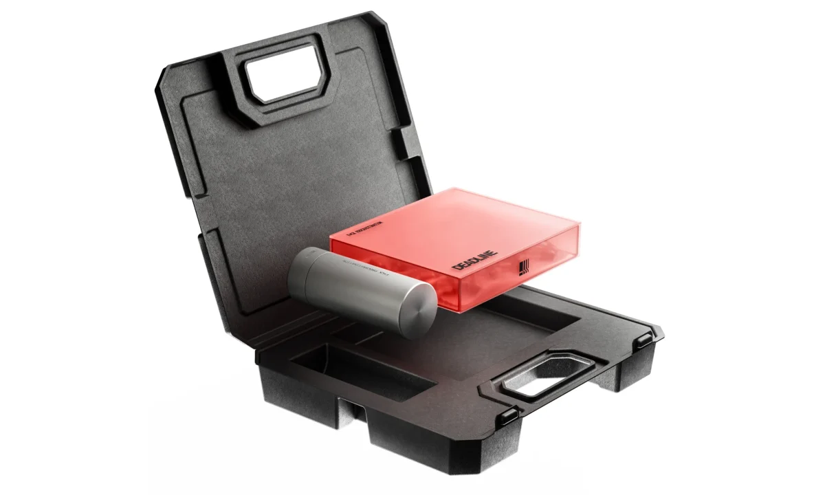 Open black protective carrying case with molded compartments, a red rectangular device, and a gray cylindrical accessory on white.