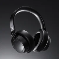 Black over-ear wireless headphones with padded ear cups and a sleek curved headband, photographed against a dark background for a premium, modern tone.