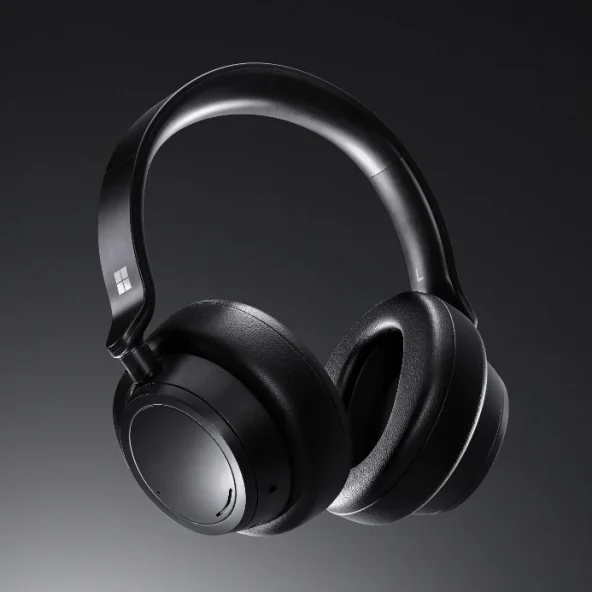Black over-ear wireless headphones with padded ear cups and a sleek curved headband, photographed against a dark background for a premium, modern tone.