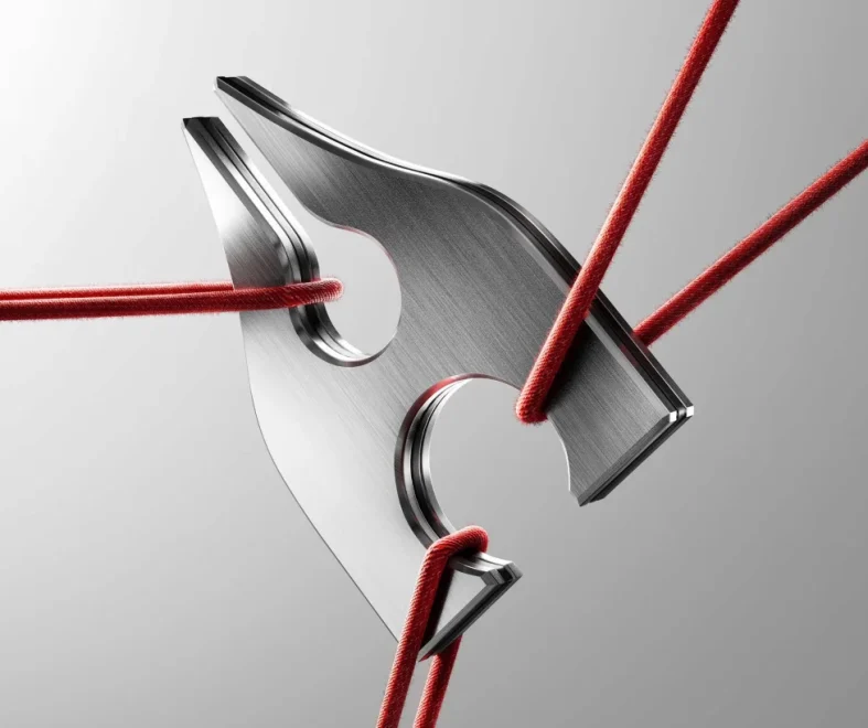 Brushed metal triangular plate with curved cutouts, threaded by taut red cords against a gray background, suggesting tension and precision.